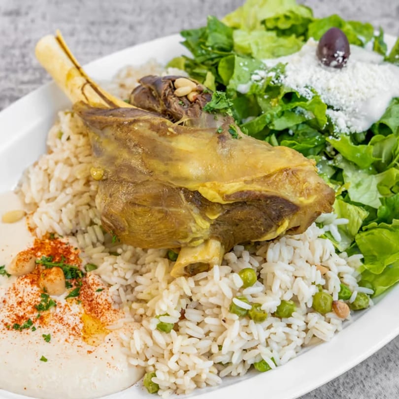 Albasha Express's lamb shank with rice, peas, hummus, and a side salad with feta and an olive.